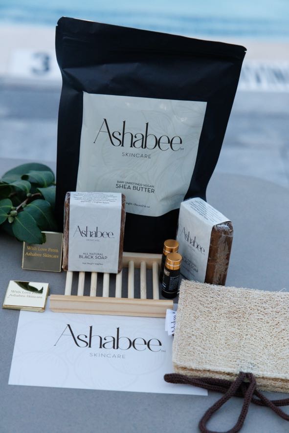 Everything inside the Kaziri Box: shea butter, two black soap bars, a wooden soap dish, botanical oil, a loofah and a card